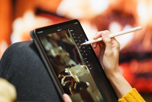 A person creating digital artwork on a tablet, surrounded by creative tools, illustrating the process of generating images with artificial intelligence.