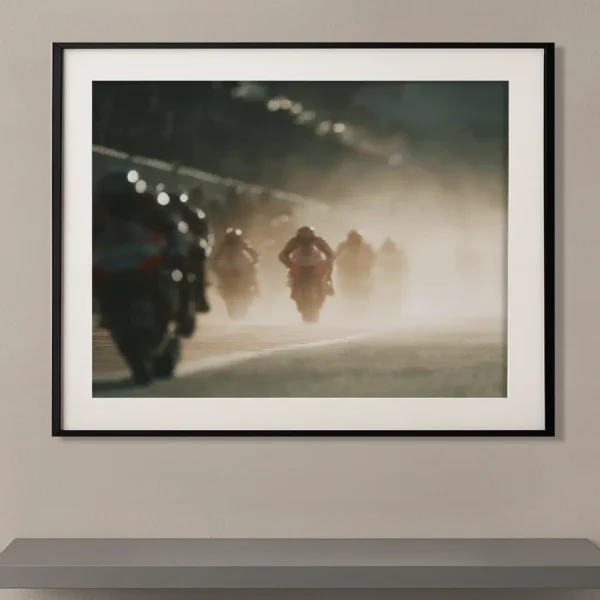 Tableau moto GP en mouvement avec pilotes floutés dans un cadre noir Graphic Avenue