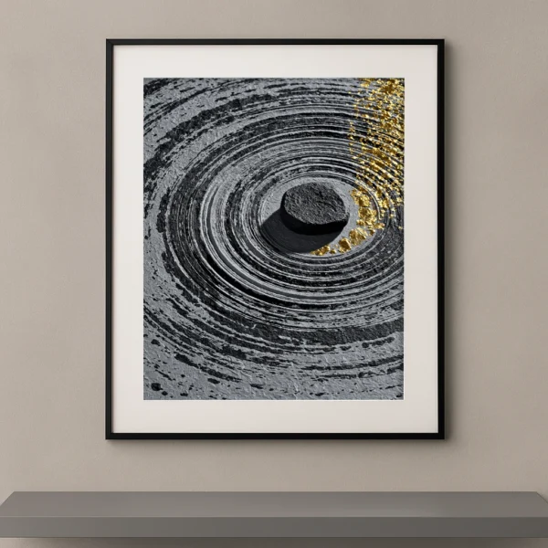 Tableau zen contemporain représentant une pierre noire au centre de cercles concentriques gravés dans une matière minérale avec des éclats d'or inspirés des jardins japonais.