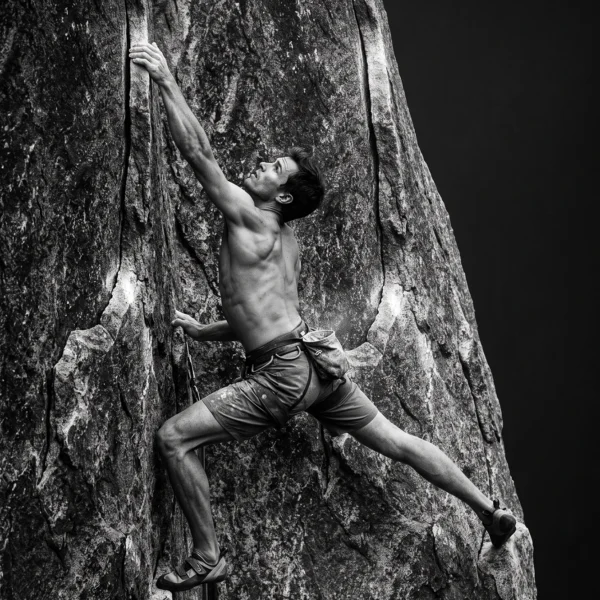 L'Ascension — grimpeur suspendu à une paroi rocheuse, effort et tension musculaire, noir et blanc, art mural premium