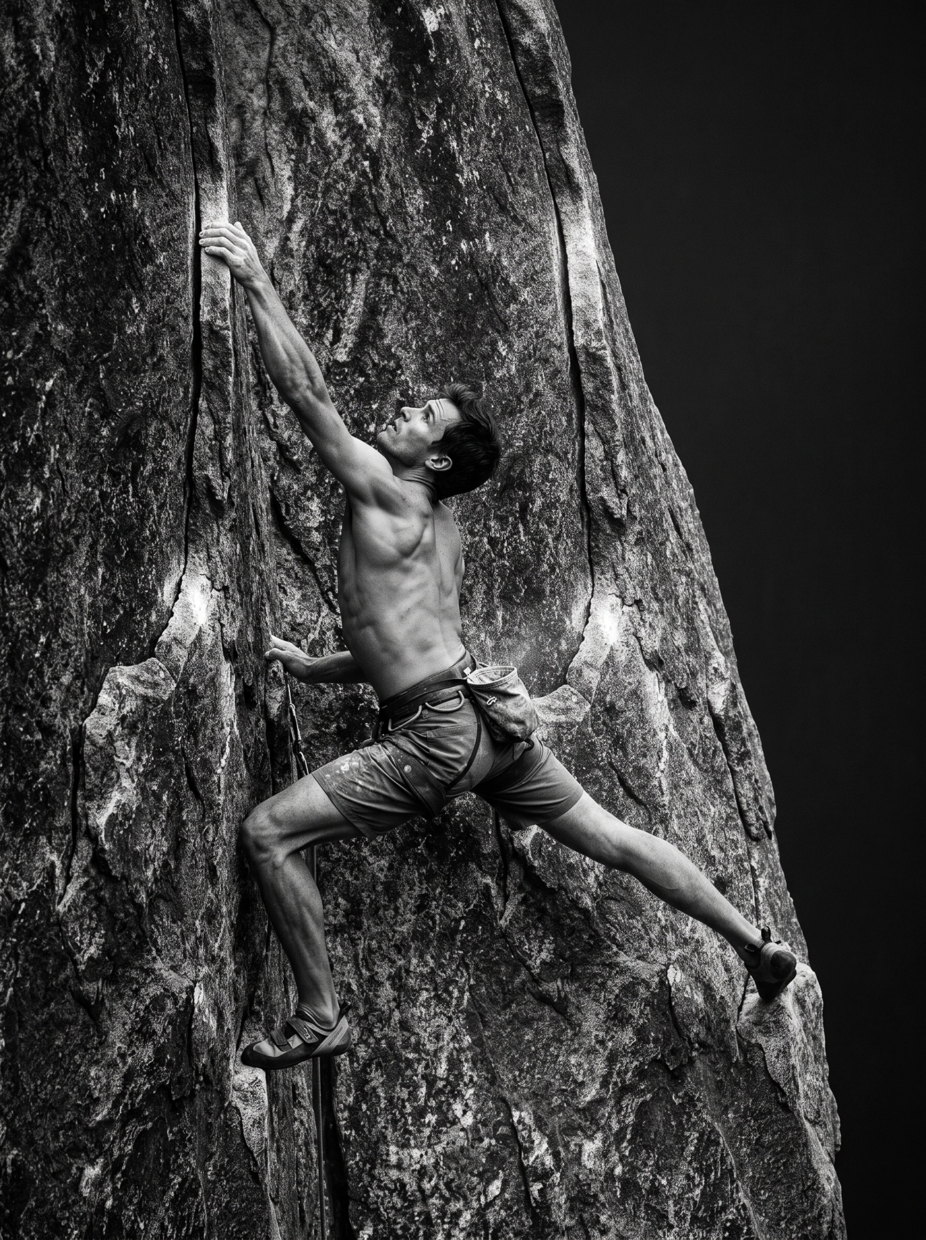 L'Ascension — grimpeur suspendu à une paroi rocheuse, effort et tension musculaire, noir et blanc, art mural premium