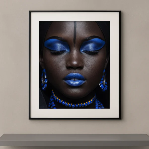 Portrait artistique de beauté ethnique avec maquillage bleu cobalt, yeux fermés, lèvres bleues et bijoux assortis sur fond noir.