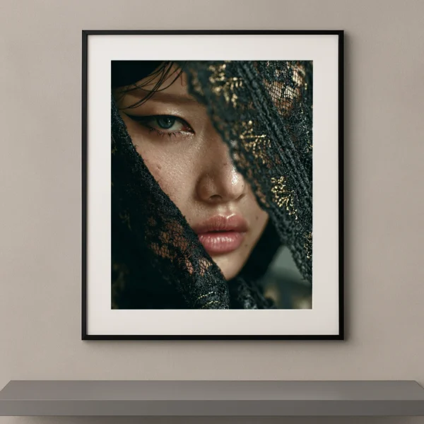 Portrait artistique d'une femme au regard intense derrière une dentelle noire brodée d'or dans un style photographique contemporain.