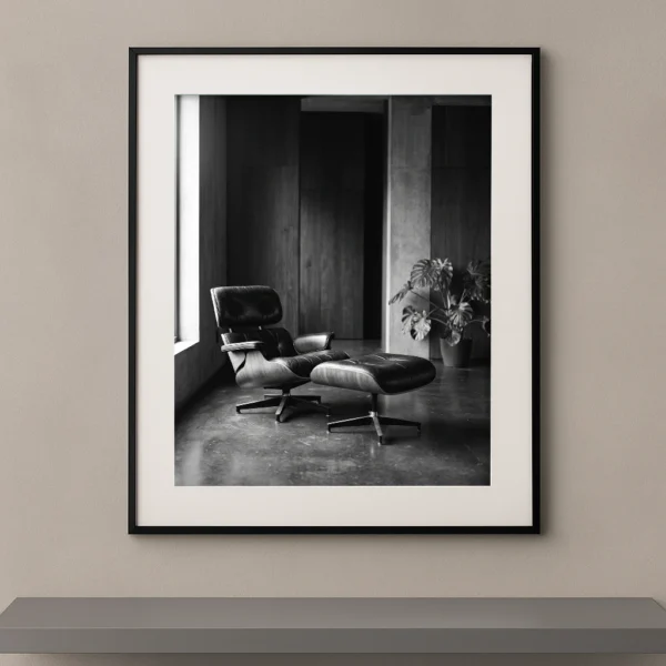 Tableau noir et blanc d'un fauteuil Eames Lounge Chair dans un intérieur brutaliste