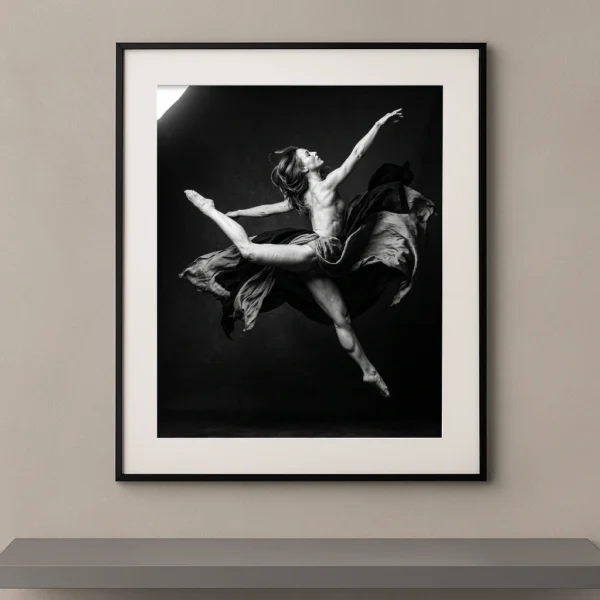 Tableau noir et blanc d'une danseuse en plein saut entourée d'un tissu en mouvement