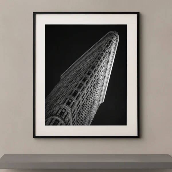 Tableau noir et blanc du Flatiron Building photographié en contre-plongée