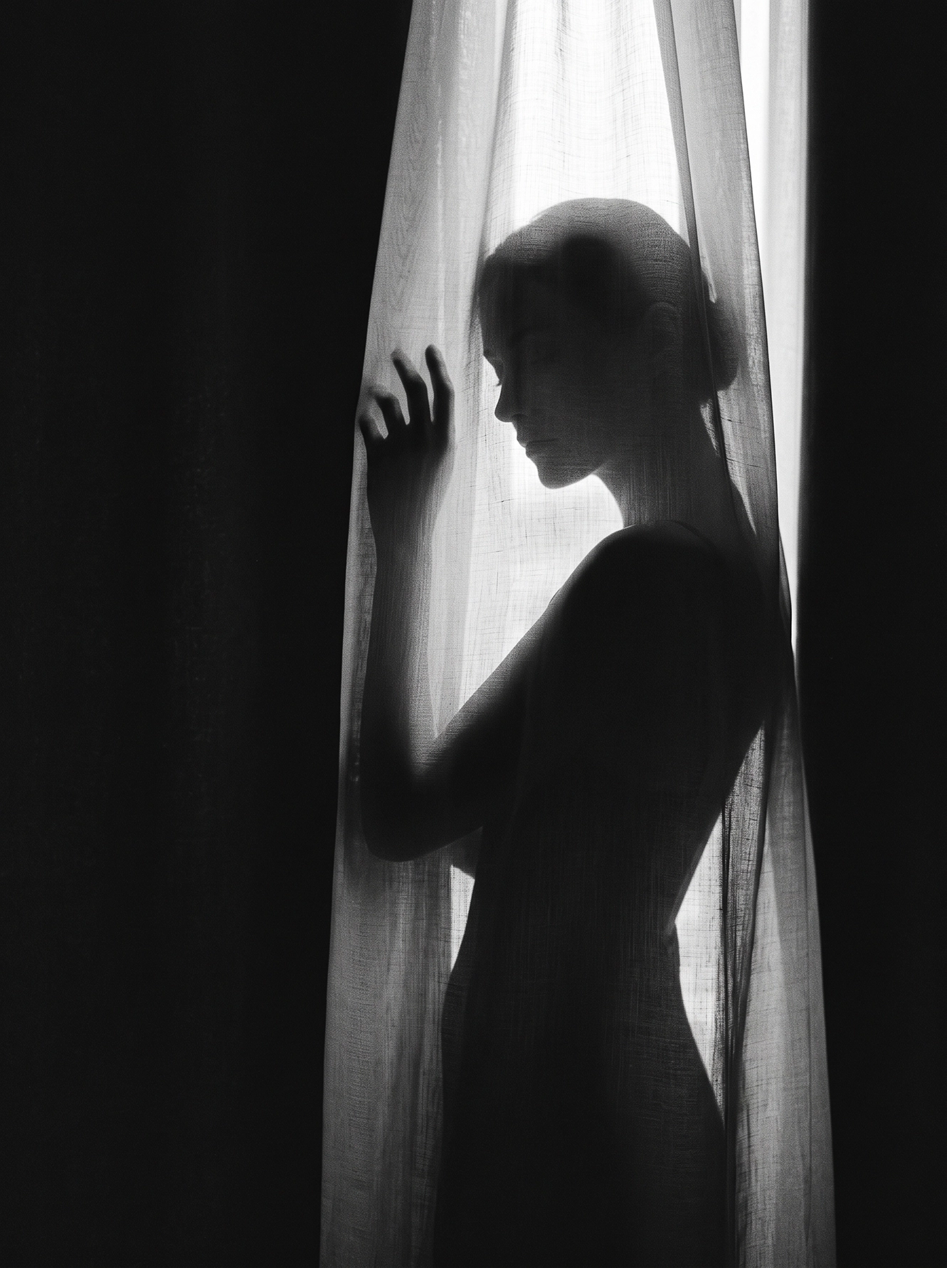 Derrière le Voile — silhouette féminine à travers un rideau translucide en contre-jour, noir et blanc, art mural premium
