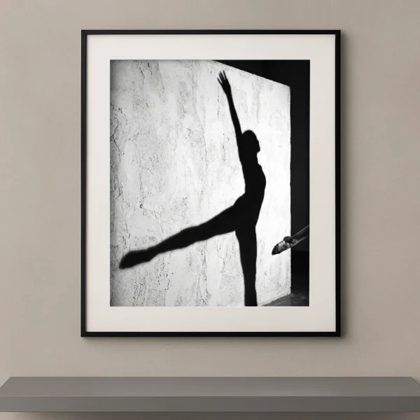 Tableau noir et blanc représentant l’ombre d’une danseuse projetée sur un mur clair texturé