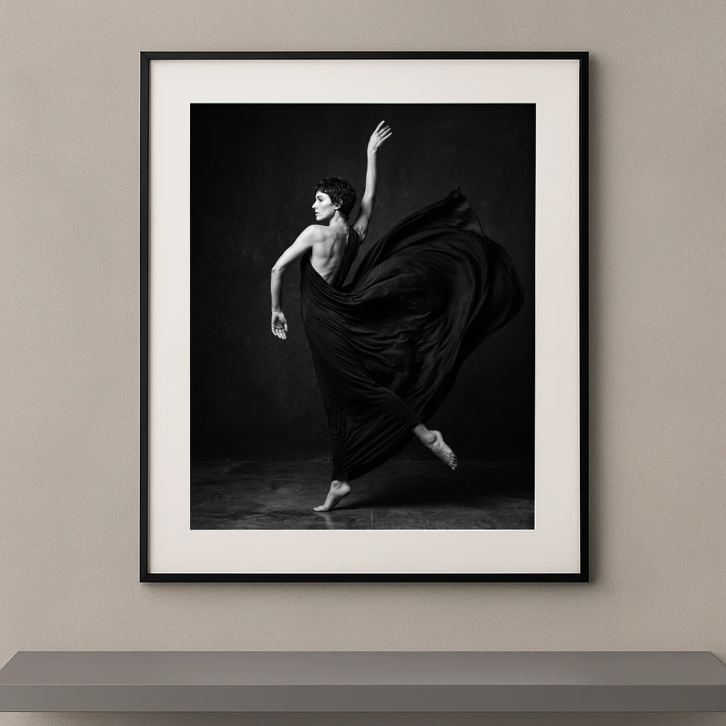 Tableau noir et blanc d'une danseuse enveloppée dans un spectaculaire mouvement de tissu sombre