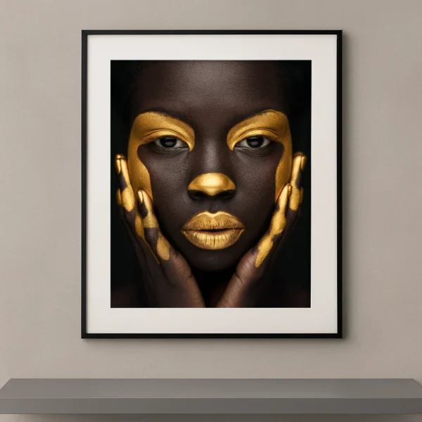 Portrait artistique de beauté ethnique avec maquillage doré graphique, visage de face et fond noir minimaliste.