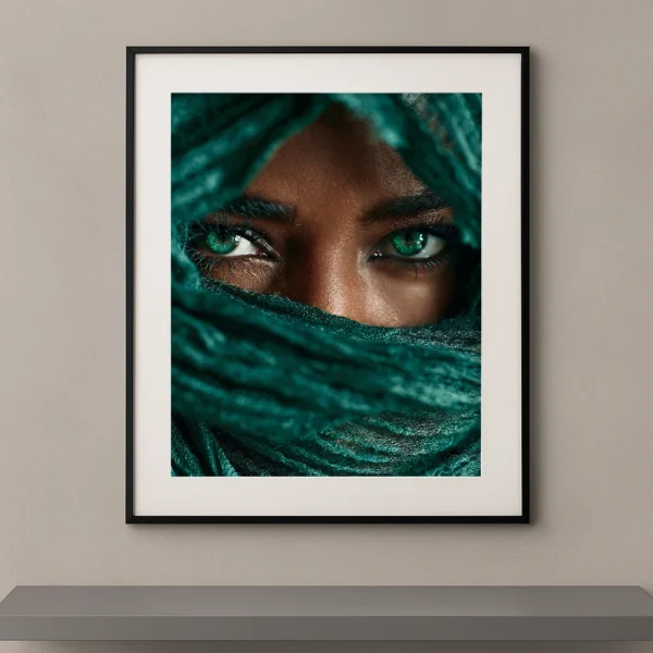 Portrait artistique d'un regard vert émeraude intense apparaissant derrière un voile bleu-vert dans un style photographique Fine Art contemporain.