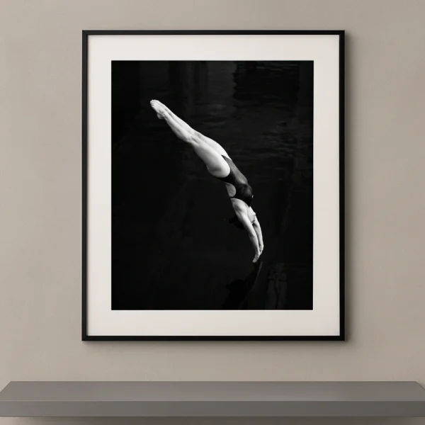 Tableau noir et blanc d'une plongeuse entrant verticalement dans l'eau