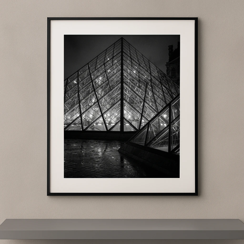 Tableau noir et blanc de la pyramide du Louvre illuminée de nuit à Paris