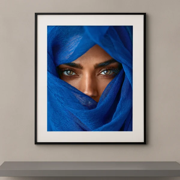 Portrait artistique d'une femme au regard intense apparaissant à travers un voile bleu cobalt dans un style photographique contemporain.