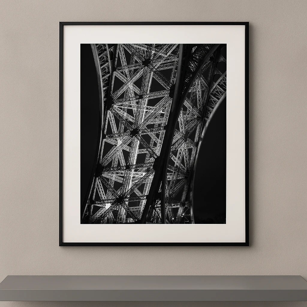 Tableau noir et blanc des structures métalliques de la Tour Eiffel vues en contre-plongée