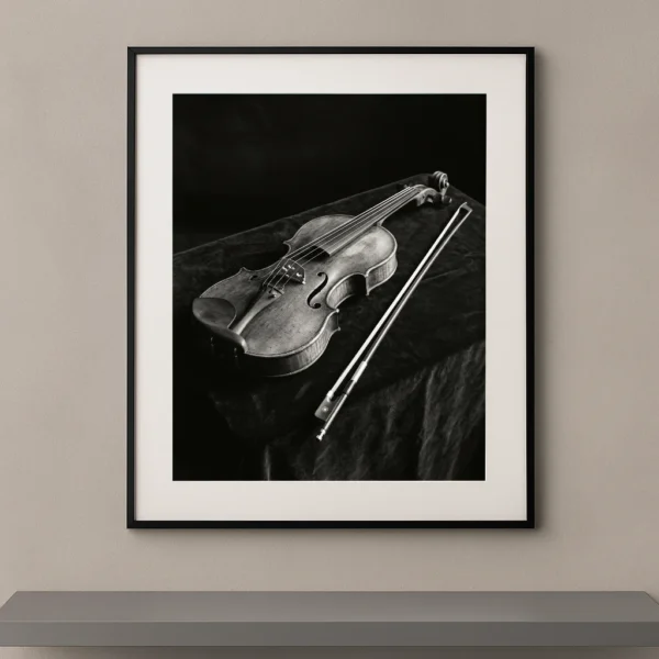 Tableau noir et blanc d’un violon ancien Stradivarius posé sur du velours sombre