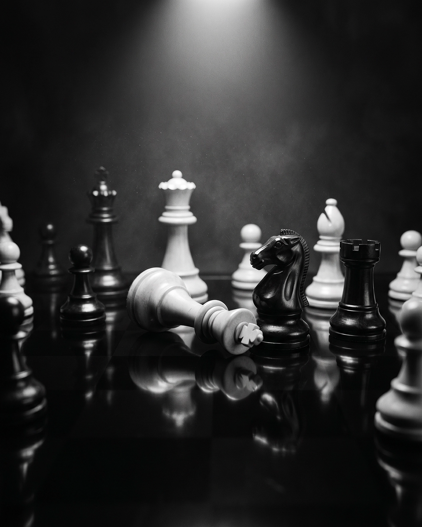 Échec et Mat — roi blanc renversé sur un échiquier Staunton, lumière dramatique, nature morte noir et blanc, art mural premium