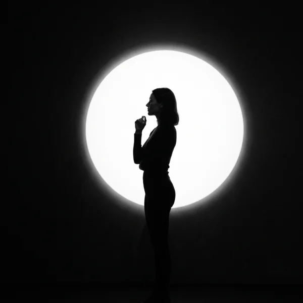 Éclipse Intérieure — silhouette féminine face à un immense cercle de lumière blanche, composition minimaliste noir et blanc, art mural premium