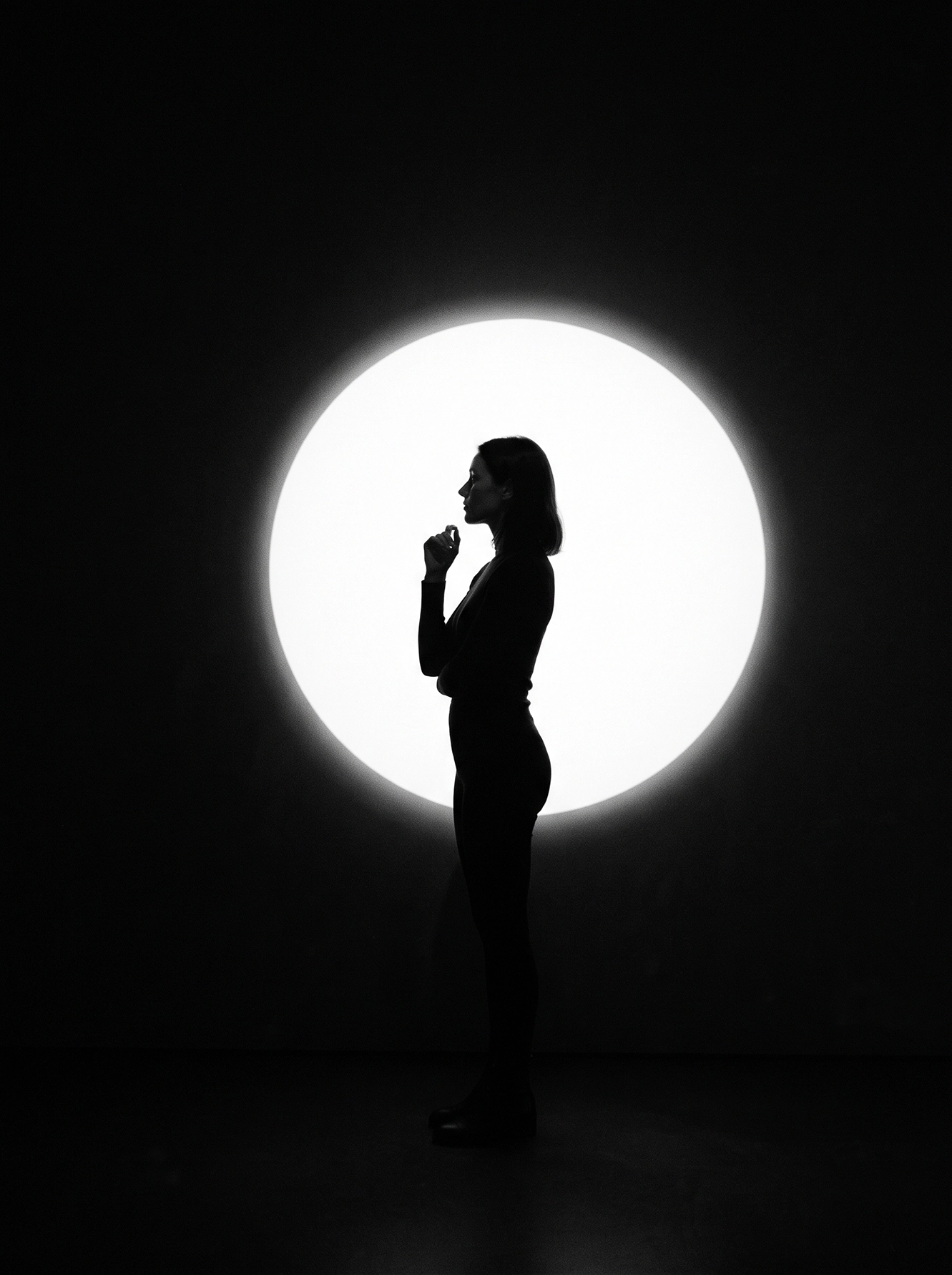 Éclipse Intérieure — silhouette féminine face à un immense cercle de lumière blanche, composition minimaliste noir et blanc, art mural premium