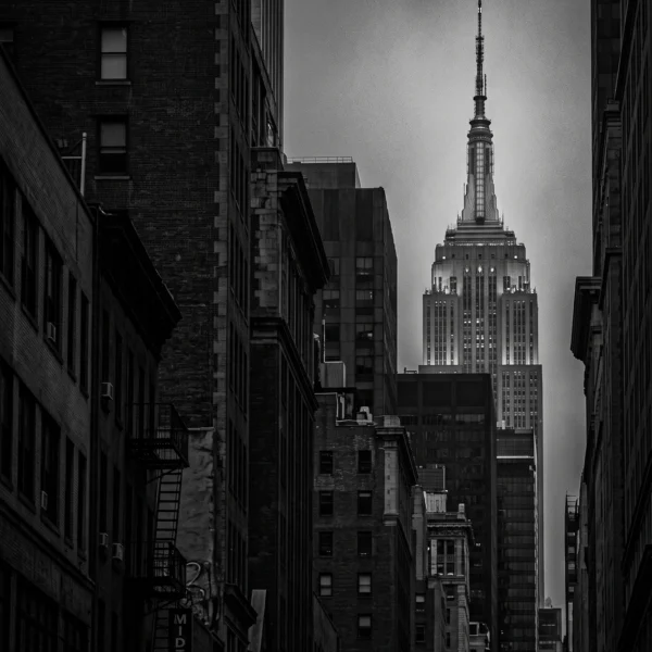 Empire State Perspective — gratte-ciel Empire State surgissant d'un canyon urbain, noir et blanc, art mural premium