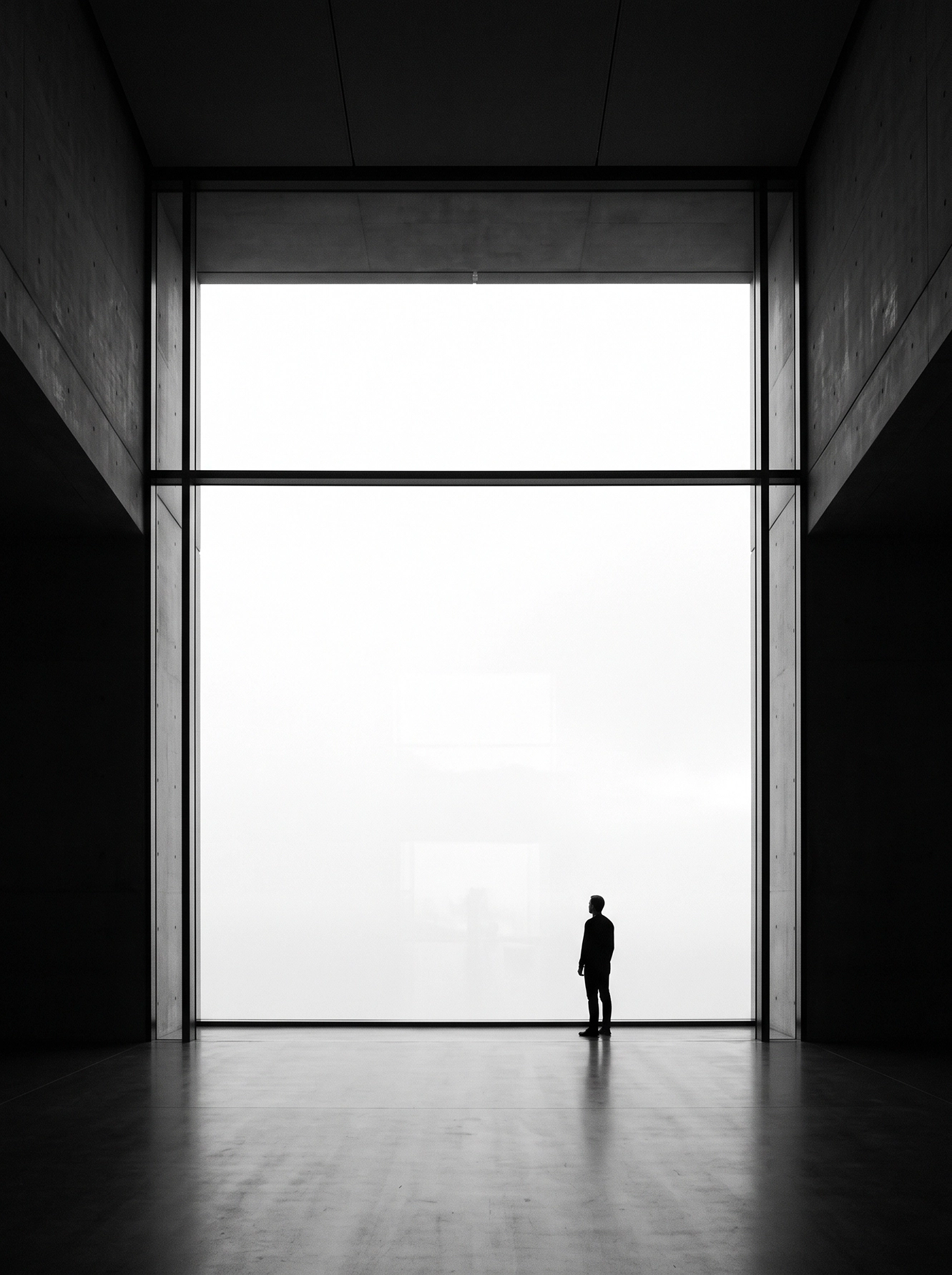 Face au Vide — minuscule silhouette face à une architecture monumentale et une ouverture blanche, noir et blanc, art mural premium