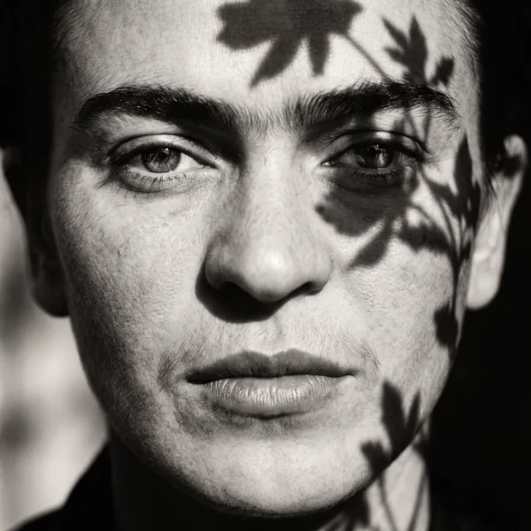 Frida Kahlo — Fleurs d'Ombre, portrait frontal avec végétation formant un masque naturel, noir et blanc, art mural premium
