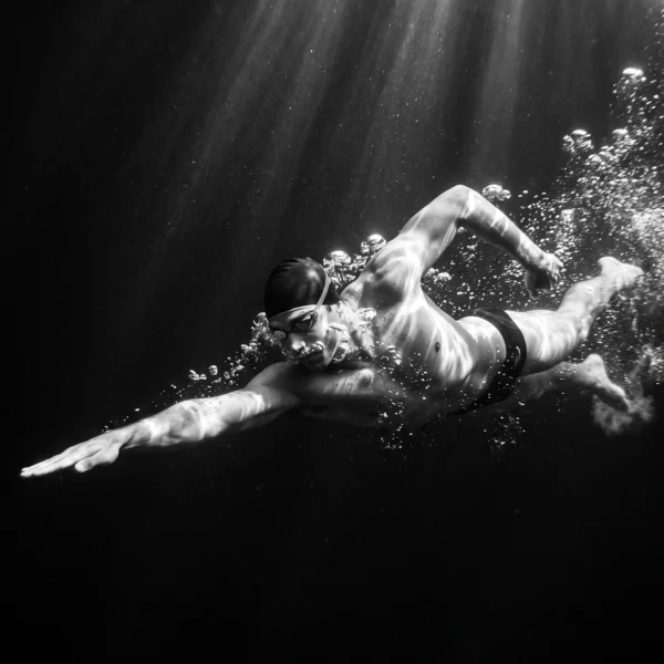 Immersion — nageur sous l'eau, corps tendu parmi les bulles, photographie noir et blanc, art mural premium