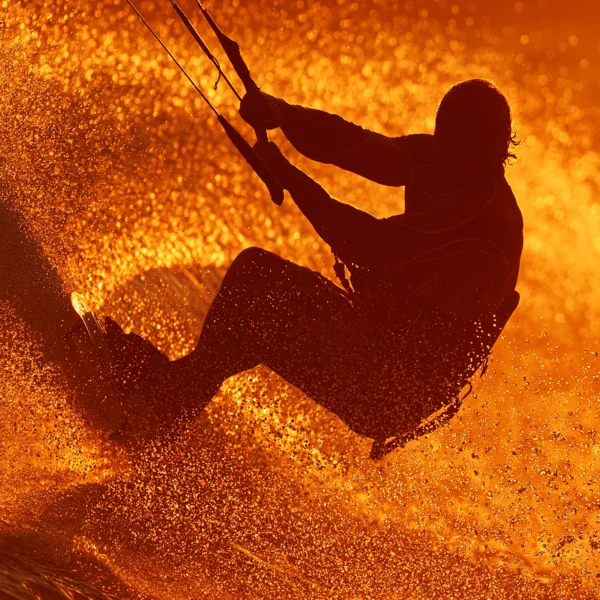 Kitesurf — silhouette de kitesurfeur jaillissant d'une explosion de gouttelettes d'eau dorées, art mural premium