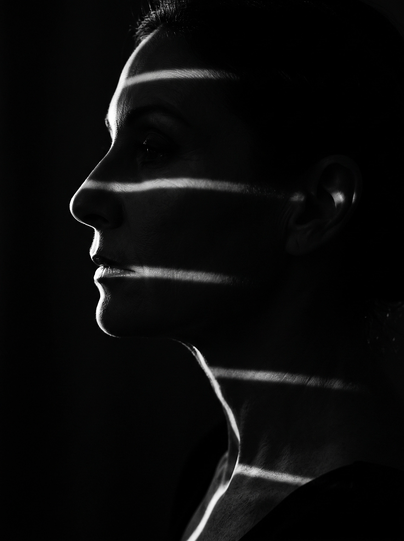 Lignes de Lumière — visage féminin dans l'obscurité traversé de fines bandes lumineuses, noir et blanc, art mural premium