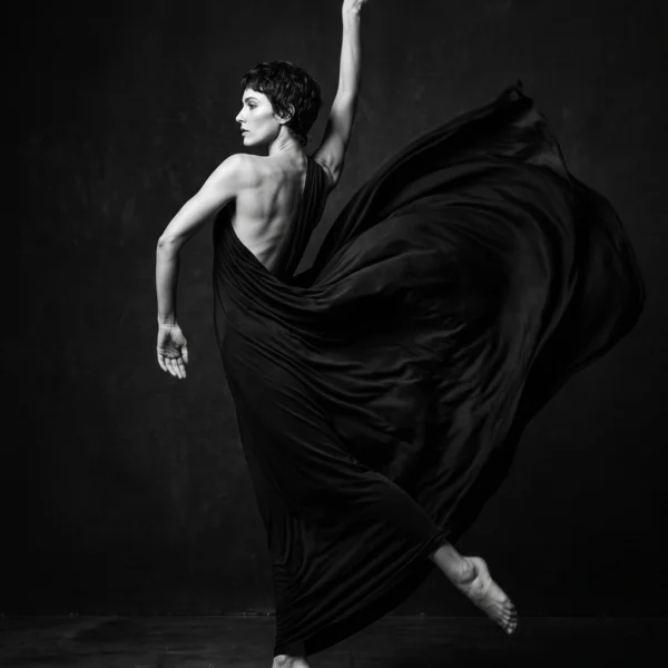 Métamorphose — danseuse fusionnant avec un vaste tissu noir en mouvement, photographie noir et blanc, art mural premium