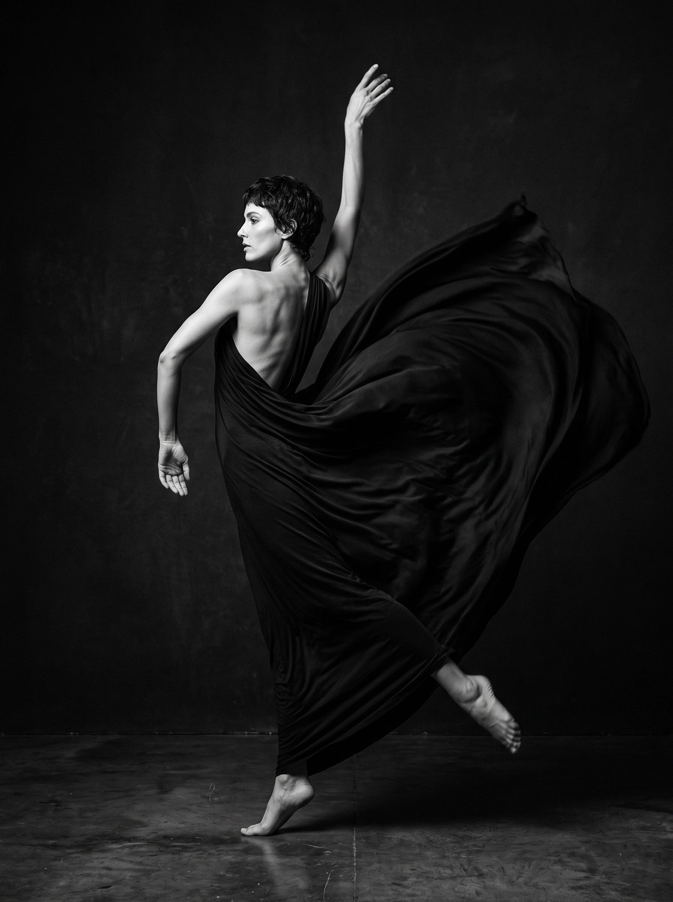 Métamorphose — danseuse fusionnant avec un vaste tissu noir en mouvement, photographie noir et blanc, art mural premium