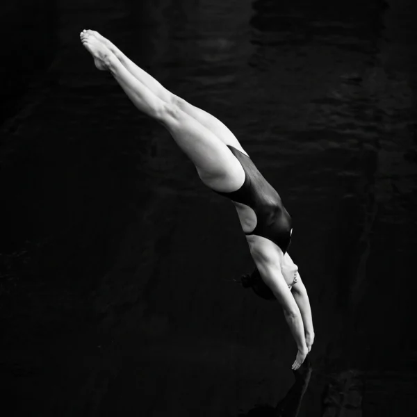 Plongée — athlète au moment précédant l'entrée dans l'eau, corps aligné, photographie minimaliste noir et blanc, art mural premium