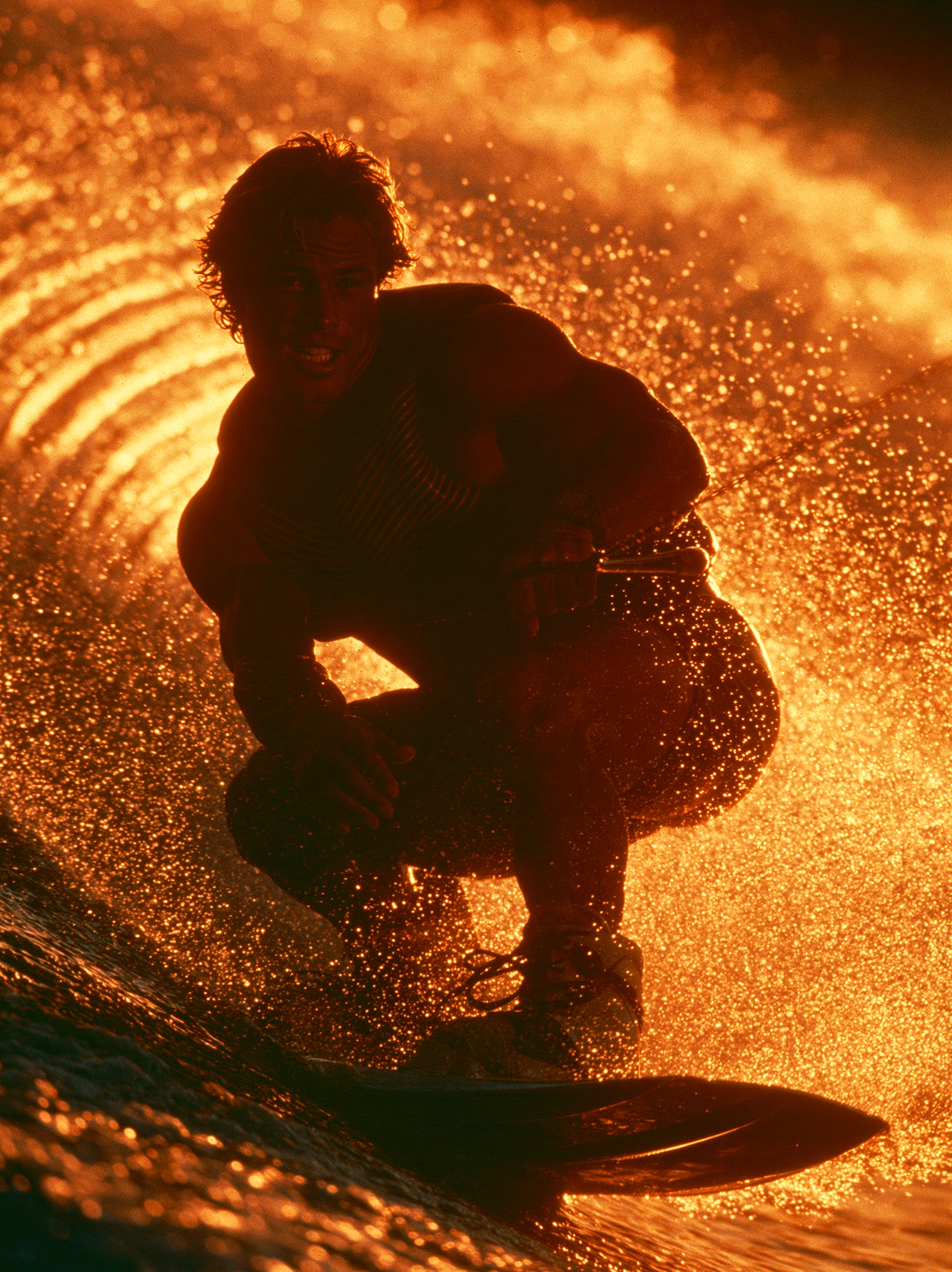 Wakeboard — wakeboardeur jaillissant d'une explosion de gouttelettes d'eau dorées à contre-jour, art mural premium
